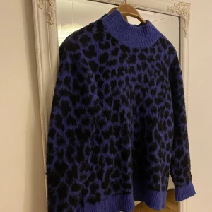 Stickad tröja  - Blå/svart-mönstrad stickad tröja från NAKD i nyskick som aldrig kommit till användning. 