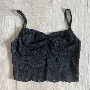 Spets topp - Spetslinne med liten schrunch vid bröstet. Banden går att justera. Dubbla tyger. 