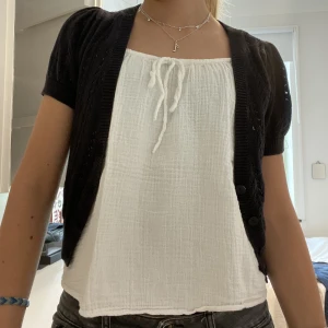 Sött kofta - Sött liten stickad kofta i svart med knappar 