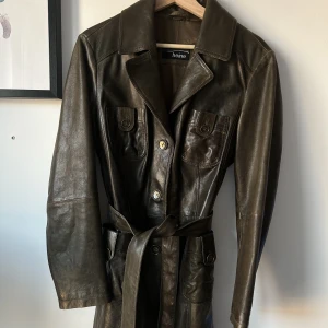 Skinnkappa vintage - Skinnkappa vintage mörkbrun med grön ton. Fint skick!! Knapert använd. Kappan går till lår/knä beroende på längd av användaren🧚🏼