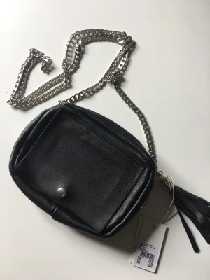Liten väska med spegel  - Svart liten väska med spegel. Axelrem i form av kedja. Nyskick, aldrig använd. 