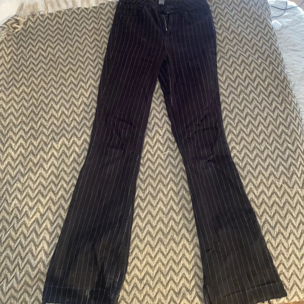 Svarta Flare jeans med vita ränder på. Använda ett fåtal gånger! Storleken är w28 L32. Har sprättat upp det längst ner så skulle säga att de är ca 2-3 cm längre!. Jeans & Byxor.