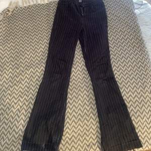 Svarta Flare jeans med vita ränder på. Använda ett fåtal gånger! Storleken är w28 L32. Har sprättat upp det längst ner så skulle säga att de är ca 2-3 cm längre!