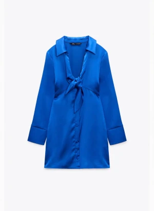 Klänning med knytning - Blå satin klänning med knytning. Oanvänd med prislapp. I bra skick och sann till strl. 