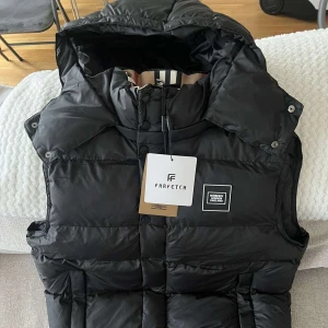 Burberry Vest - Upptäck nya svarta Burberry-väst Tillverkad av högkvalitativa material för optimal komfort och hållbarhet. Helt ny med Farfetch-lappar kvar, vilket garanterar äkthet. Perfekt för både vardag och formella tillfällen.