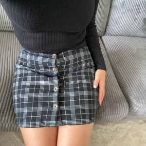 Rutig minikjol - Söt rutig kjol med knapp detaljer framtill som går att knäppa av. 