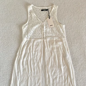 Bik Bok vit lång topp med spets - Otroligt fint linne med spets från Bik Bok. Nytt med tags kvar, men har en liten smutsfläck på ryggen (går förmodligen bort i tvätt). 