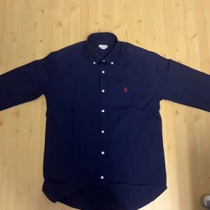 U.S. Polo Skjorta - Helt oanvänd polo skjorta som ja nu säljer då den inte passar på mig och tyckte inte om den så sjukt mycket och har även orderbekräftelsen för de som vill se.