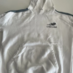 Hoodie med tryck - En vit hoodie med tryck och ränder på armarna  Jättefint skick  Storlek S