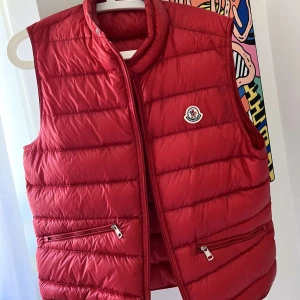 Moncler gui väst  - Säljer nu en Moncler gui väst i strl 3 vilket motsvarar M. Altt og finns! Skicket på västen 9/10. Vid frågor är det bara att höra av sig!