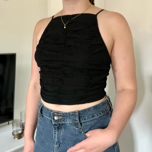 Svart topp - Svart topp med krinklat tyg. Använd ett fåtal gånger och i fint skick. 