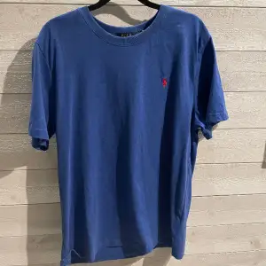 Tjena, säljer denna blå Ralph lauren t shirten i storlek XL, men sitter mer som en L. Knappt använd och i väldigt fint skick. Har likadana tröjor i andra färgen i min profil så vid köp av flera går det att lösa paketpris!!