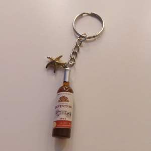 Handgjord nyckelring med 2 berlocker. En vin flaska och en liten sjö stjärna. 