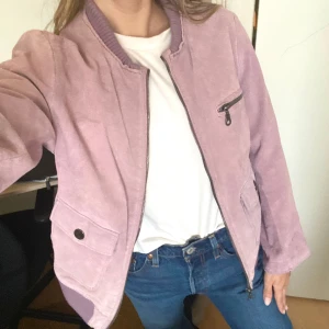Ljuslila mockajacka - Så fin ljuslila jacka i äkta mocka! Synliga styng runt ärmar och krage (se bild) och en fläck på arm (se bild) som jag ej testat ta bort, tycker inte den syns! Står stl 42 men passar XS-M (Jag är S) 