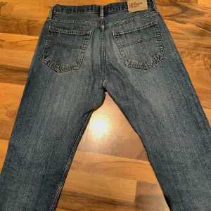 Ett par snygga tommy hilfiger jeans. Skulle säga att de är straight men lite mer baggy. Köpta på plick men används inte längre. De är lite slitna längst ner(se bild 3) men det är inget man märker av.🫶🏼 midjemått:80cm innerbenslängd:70cm