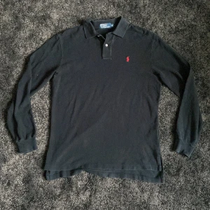 Långärmad ralph lauren piké  - Svart långärmad Ralph lauren piké i storken M. Tröjan är stor i storleken och passar även L. Perfekt skick 8.5/10. Hör av er om ni har några frågor.