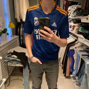 Fotbolls tröja från klubben Real Madrid  Knappt använd och perfekt för varma sommar dagar. Den är Xs och jag är 170 och den passar perfekt  Skick 10-10
