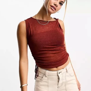 Topp i mesh tyg med ryshad detalj - Topp med ryshad detalj i mesh och knyte i sidan. Använd 1 gång💞