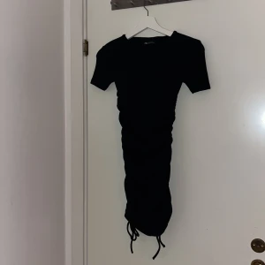 Svart klänning - Svart klänning med två band på sidorna