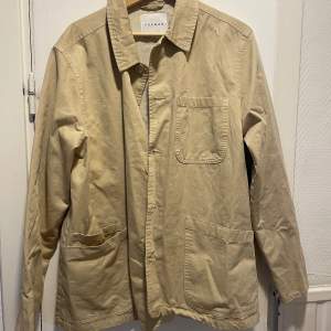 Skjortjacka i beige från Topman i stl M. Fläck 0,5cm på framsidan, se bild. 