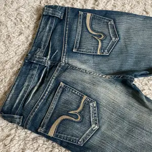 Vintage jeans från stradivarius, lågmidjad och bootcut modell med coola detaljer och wash! ❤️Innerben: 73,5cm, midja rakt över: 38cm. Jag är 167. Om fler mått önskas är det bara att skriva! 🫶 Har minimala defekter, skriv för bild. 🥰