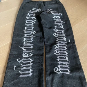 Baggy jeans med tryck  -  As coola svarta jeans med broderat tryck liknar Evisu jeans de är nästan helt nya skriv om ni ha fler frågor 
