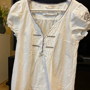 Odd Molly blus  - Fin vit kortärmad Odd Molly blus med märke på ärmen och knappar fram. Storlek 2 vilket motsvarar storlek M / 38.   Sparsamt använd. 