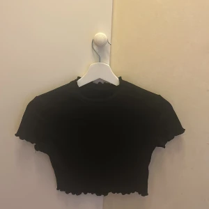 En svart kortärmad tröja  - Den är från SHEIN, Den är använd, Lite kort