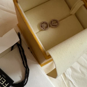 FENDI örhängen!  - Säljer mina Fendi örhängen  Ord pris: ca 3000kr  Kvitto med följer och allt på bilden! DOCK SAKNAS PLOPPEN PÅ BÅDA DÄRAV PRIS OCH LITE SLITAS PÅ ÖRHÄNGERNA❤️