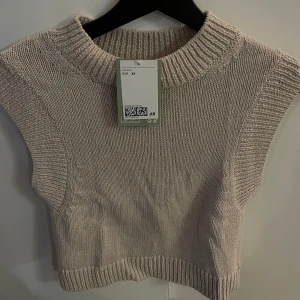 Stickad väst - Stickad väst i en beige färg, strl xs. Helt ny med prislAPP