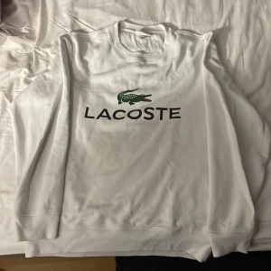 Lacoste Crewneck - Tjena, här är en fet Lacoste tröja som legat lite för länge i garderoben utan användning och tror att den gör mer nytta hos någon annan. Kan inte säga mycket mer än att den varit väl älskad här. PRUTA GÄRNA!