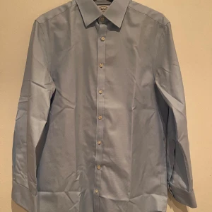 Kostyskjorta - Blå kostym skjorta i lyxigt bomullstyg. Perfekt för sommarens fester och bravader. Slimad passform, men för kort i ärmen för mig.