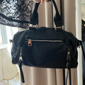 Handväska - Perfekt svart handväska som funkar till allt! Mycket rymlig! Något sliten på vissa delar men inget som syns direkt. Därav priset