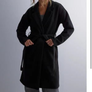 Svart kappa - En svart lång kappa med snören från Nelly. Superfin och i bra skick! Skriv för egna bilder🩷  