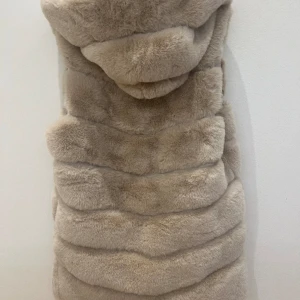 Pälsväst  - Beige lång väst med mycket mjukt päls. Nyskick. Passar XS-M. Perfekt till både vår och höst. 