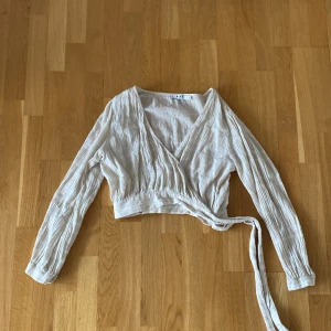 Blus med snörning  - Blus med snörning på sidan från NA-KD. Nästan helt oanvänd.