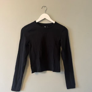 Svart basic topp  - Svart basic topp från Bikbok. Tight passform med långa ärmar. 