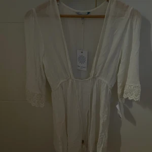 Strandklänning  - Strandkläningen är aldrig andvänd och har fortafarnde taggen kvar. Den går att shystera om i midjan med banden ! 