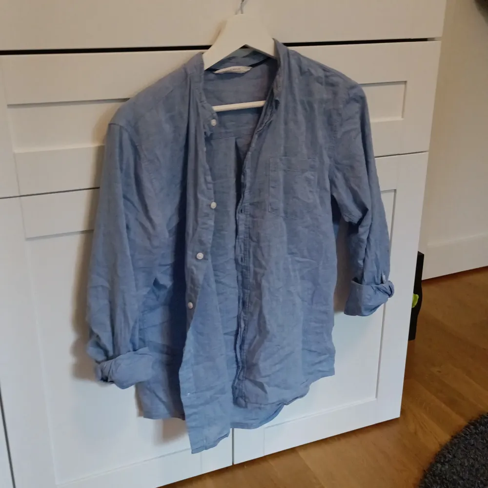 En blå linne skjorta i storlek 164 men passar som en S lite sliten inuti men har lagats. Skjortor.