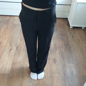 Kostymbyxor  - Svarta midwaist kostymbyxor, 2 fickor fram, 2 fejkbakfickor, bra skick