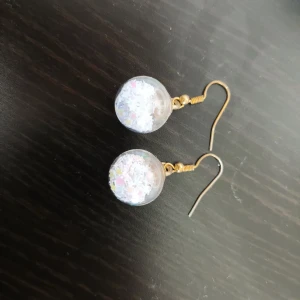 Örhengen  - Så fina örhengen i glass med lila sjärnor inte andvända.