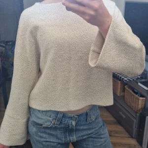 Tröja - Vit tröja med utsvängda armar. Knappar baktill som liten detalj. 