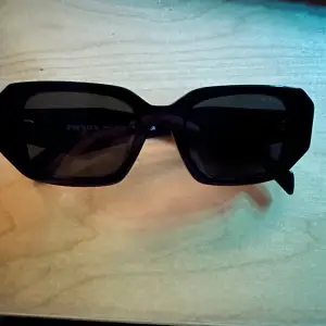 Jättesnygga solglasögon från Prada. Använda men bra skick, ända problemet är loggan av ena sidan som har skrapats bort lite.
