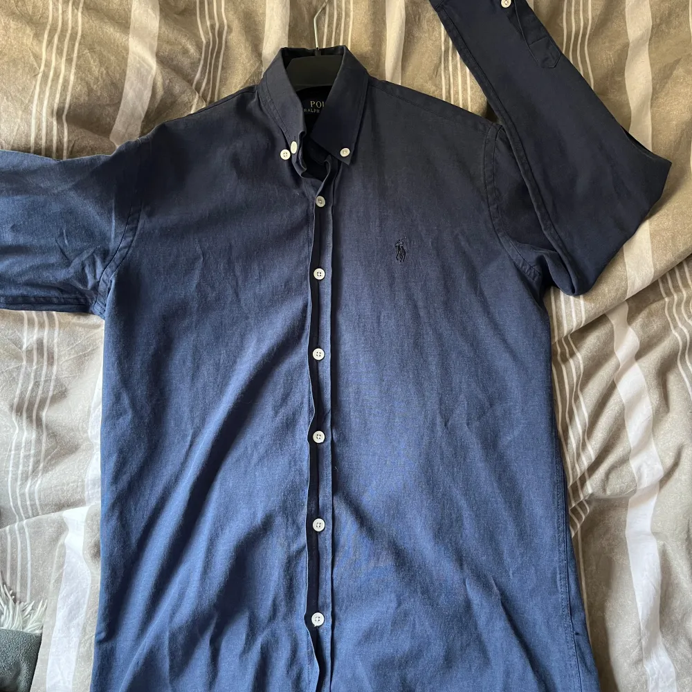 Hej, jag säljer en riktigt snygg Ralph lauren skjorta ”Custom fit”, storlek medium men passar small. Riktigt fint skick! Skriv för fler frågor & bilder. Skjortan är mörkblå med en mörkblå logga, snygg kontrast.. Skjortor.