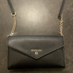 Michael kors axelremsväska  - En Michael kors väska med avtagbara band som är perfekt för fest men även vardags. Mycket rymlig. Köptes för 2 år sen från aboutyou för 1809kr. Funkar även som en plånbok.