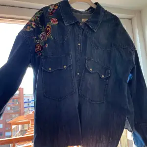 Sparsamt använd skjorta  med blomma brodering i jeans material 