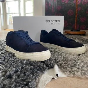 Selected home skor - Blåa selected home skor i fint skick. Inte använda alls mycket. Det är inga fel på dom förutom några jätte små slitningar i hälen. Nypris runt -:1300kr