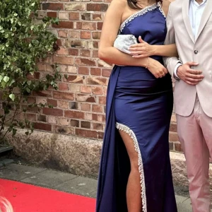 Balklänning - Säljer min balklänning, passar en M. Man kan även du in den lite utan att det syns.  Kemtvättad efter balen så den är helt som ny!