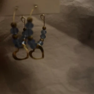 Blåa örhängen med ett hjärta - Jätte vackra örhängen!  Köpt i Turkiet och aldrig använda. Vet ej om de är nyckelfria!!