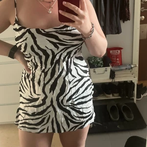 Zebra klänning - Säljer denna fina klänning i zebra mönster från Bershka. Storlek M men skulle säga mer som xs/s. Justerbara band och fin urringning. Materialet är lite satin aktigt🫶🏻 Köparen står för frakt